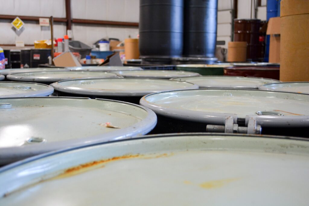 Collection of hazardous waste barrels with sealed lids.