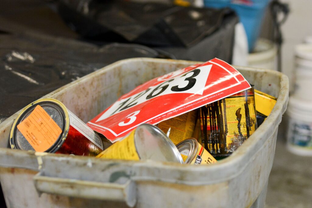 A bin full of woodworking stains and finishes, one of the common kinds of hobbyist chemicals.